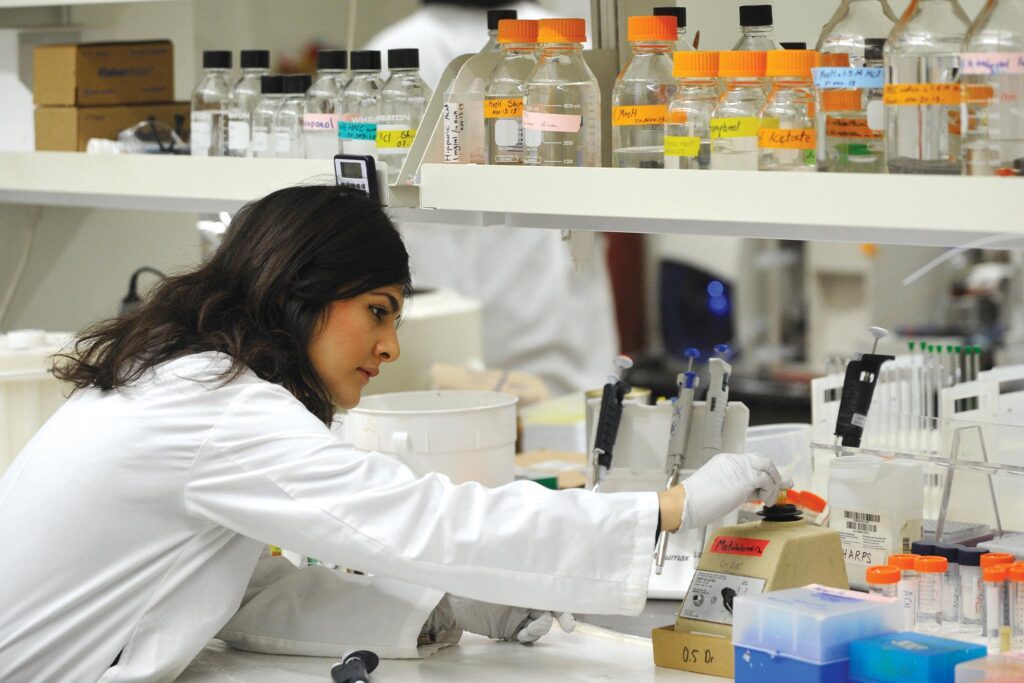 Lab worker in white coat working in lab.
