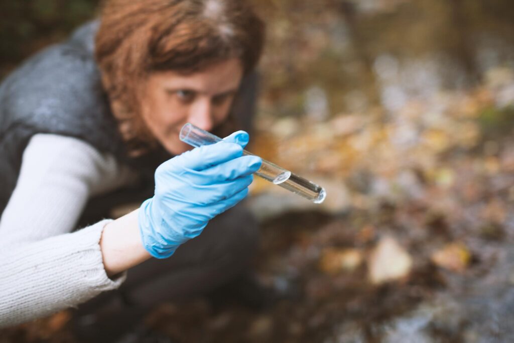 Femme chercheur collectant des échantillons d'eau