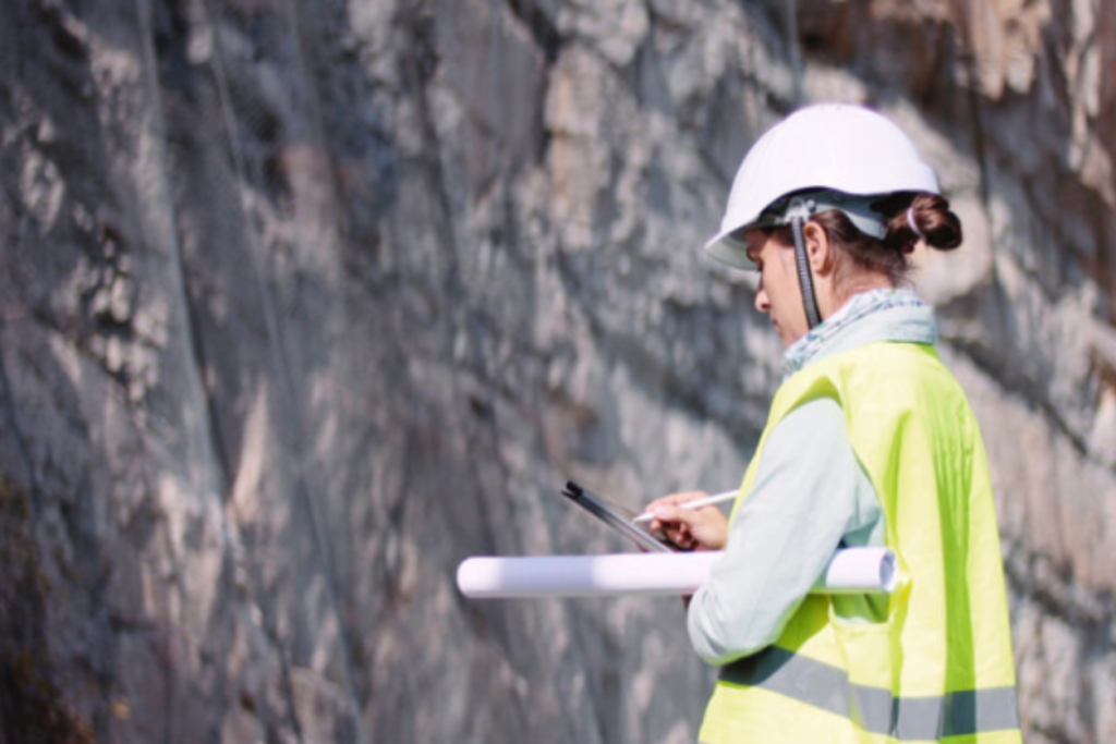 Woman engineer standing before a rock wall
